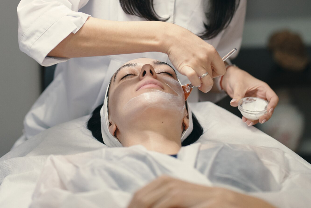 Skincare specialist applying a facial treatment to a client at a Scarborough med spa, promoting relaxation and healthy skin.