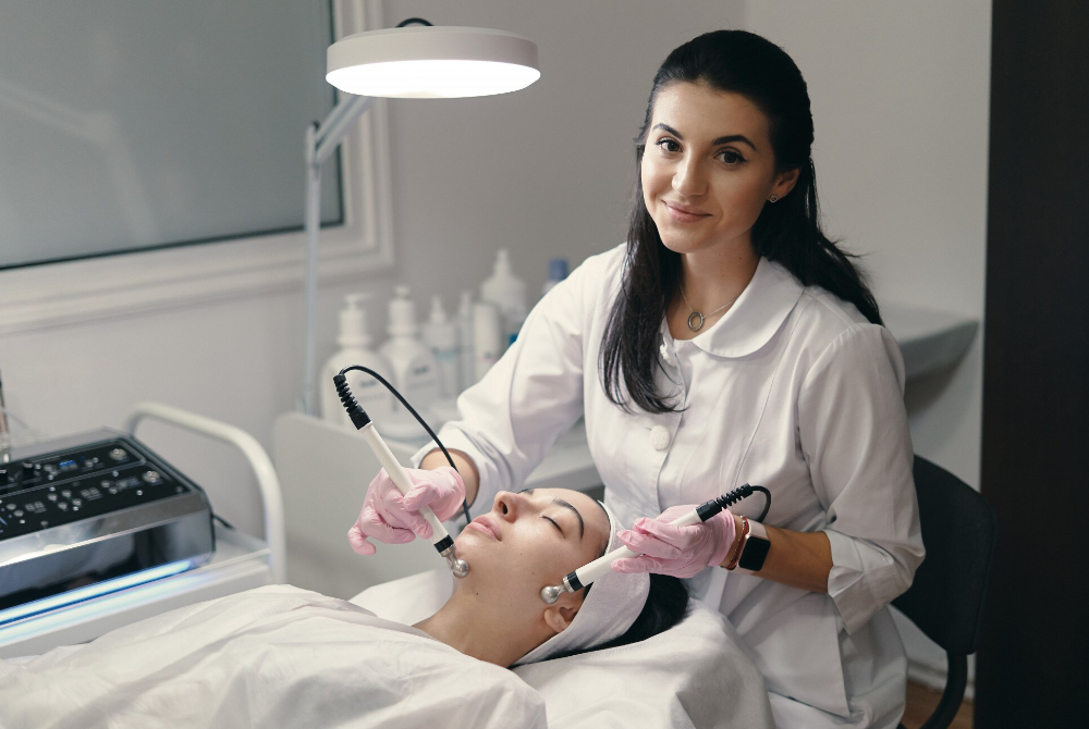 Medical aesthetician using a skincare device during a treatment.