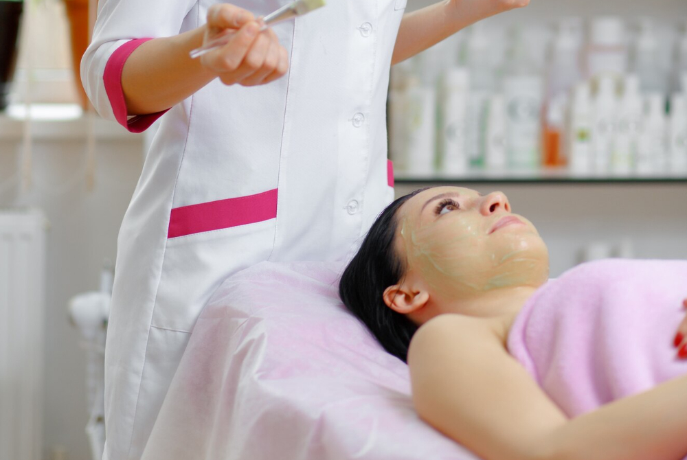 Friendly aesthetician standing in a clean treatment room.